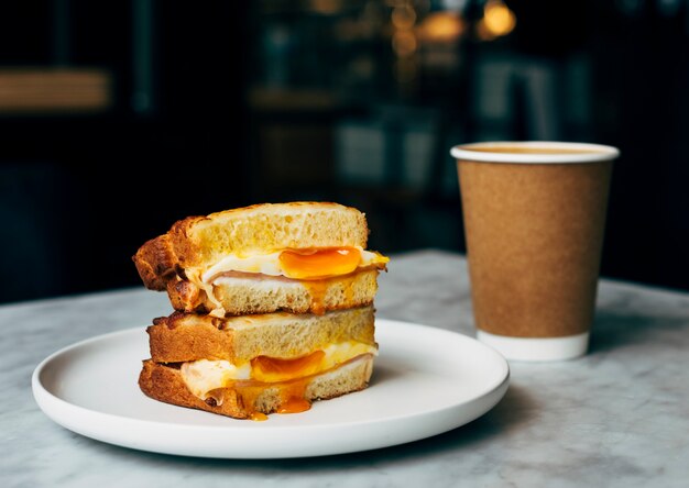 Sandwich et une tasse de café sur une table