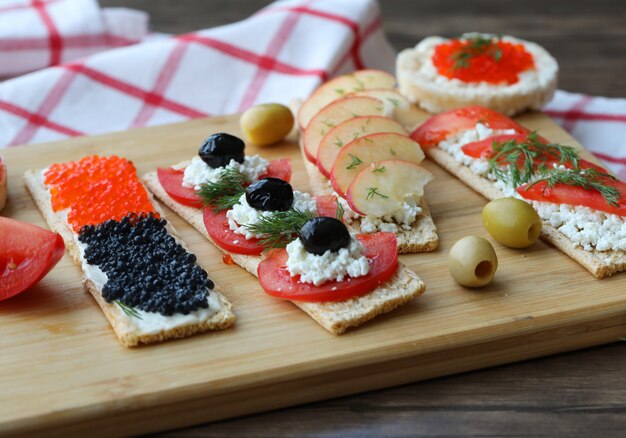 Sandwiches végétariens avec des aliments mélangés sur une planche de bois.