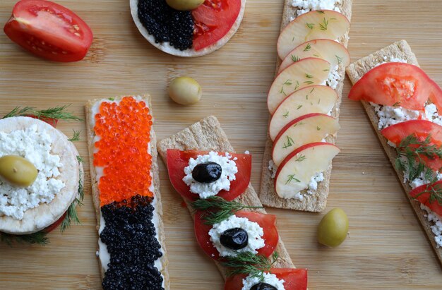 Sandwiches végétariens avec des aliments mélangés sur une planche de bois.