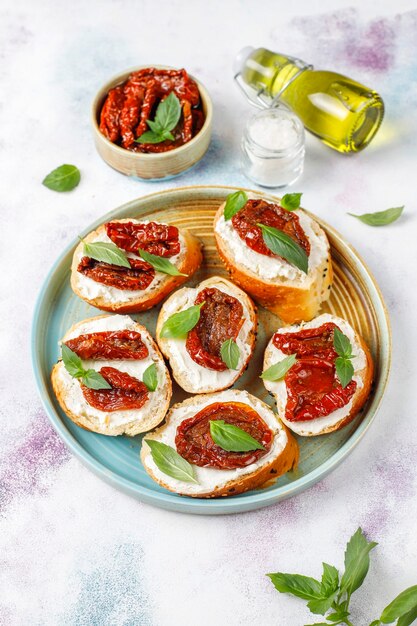 Sandwichs italiens - bruschetta au fromage, tomates séchées et basilic.