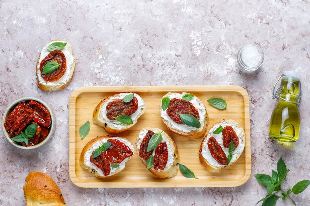 Sandwichs italiens - bruschetta au fromage, tomates séchées et basilic.