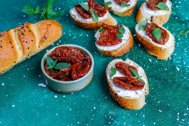 Sandwichs italiens - bruschetta au fromage, tomates séchées et basilic.