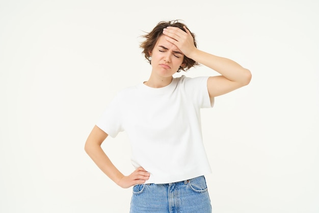 Photo gratuite santé et personnes, une jeune femme a des maux de tête, touche sa tête et grimace à cause d'une migraine douloureuse