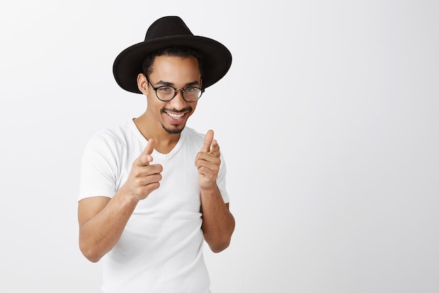 Sassy beau mec afro-américain en tenue élégante pointant les doigts, félicitations, geste bien fait