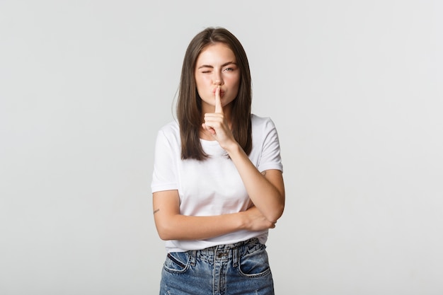 Sassy jolie fille brune clignant des yeux, chutant à la caméra, ont un secret.