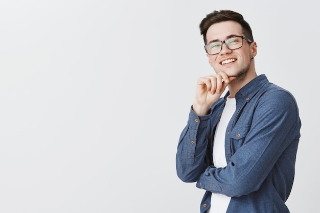 Satisfait beau mec dans des verres à la satisfaction dans le coin supérieur droit, souriant ravi