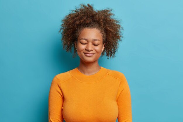 Satisfaite belle femme millénaire se tient les yeux fermés rêve de quelque chose