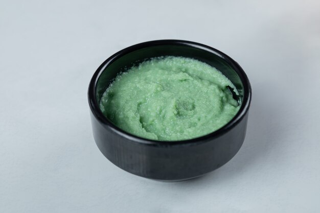 Sauce verte au wasabi dans une soucoupe noire.