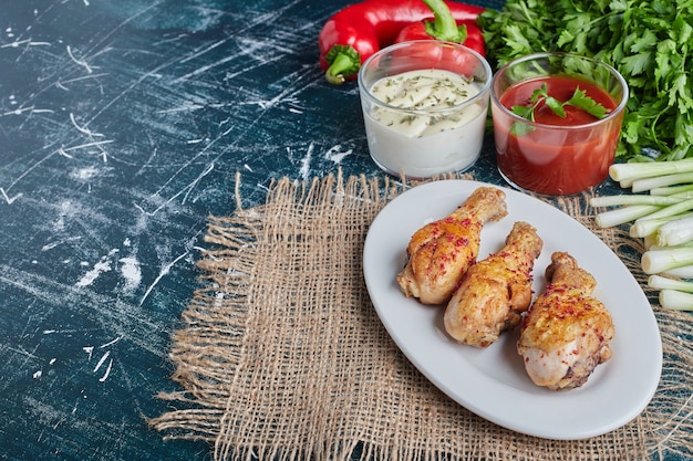 Photo gratuite sauces ketchup et mayonnaise aux herbes et cuisses de poulet crues.