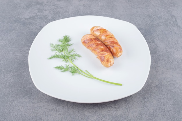 Saucisses frites dans une assiette blanche.