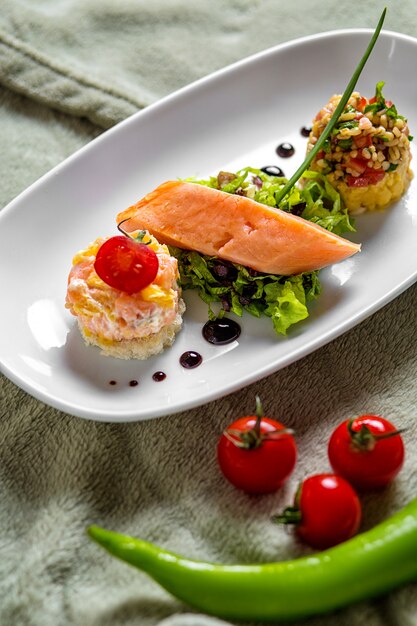 Saumon fumé servi avec petit boulgour en portion et salade