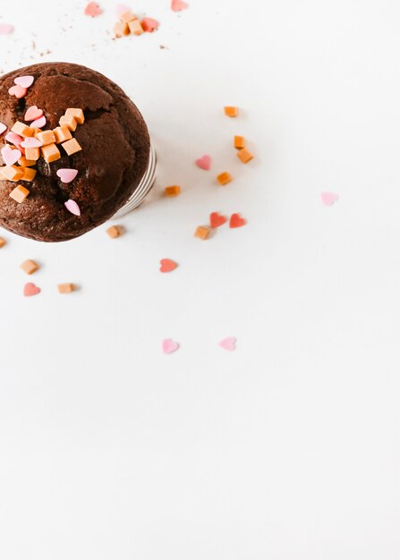 Saupoudrer et bonbons au caramel sur un gâteau au chocolat sur fond blanc