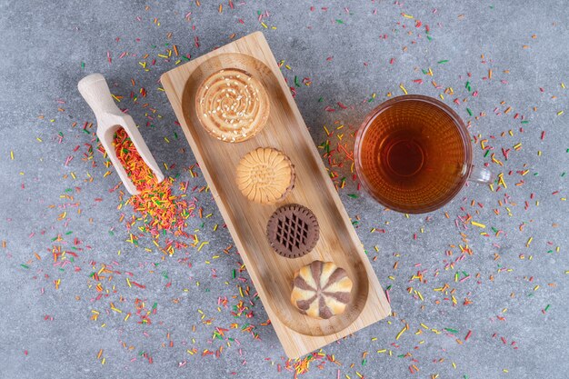 Saupoudrer de bonbons épars, une cuillère, une tasse de thé et une variété de biscuits