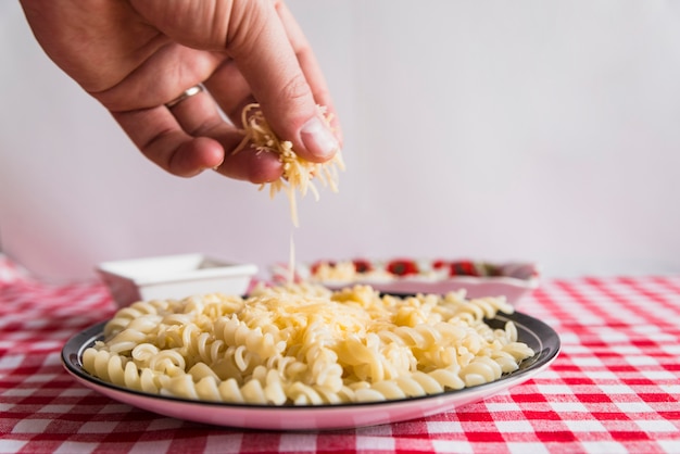 Saupoudrer le fromage sur des pâtes fraîches