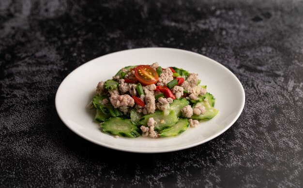 Sauté de courgettes avec du porc haché dans une assiette blanche