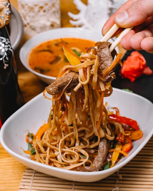 Sauté de nouilles au boeuf avec oignons de printemps et carotte de poivrons grillés