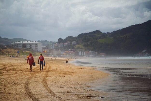 Sauveteurs s'éloignant sur la belle plage déserte