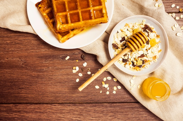 Savoureuse gaufre à l'avoine saine et au miel sur une table en bois