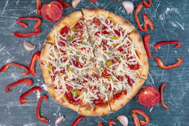 Savoureuse pizza au fromage sur bleu avec des légumes frais.