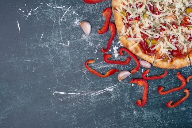 Savoureuse pizza au fromage sur bleu avec des légumes frais.