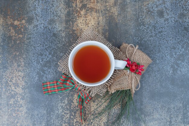 Savoureuse tasse de thé avec un bel arc sur la toile de jute.