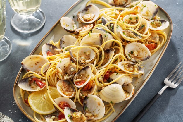 De savoureuses pâtes fraîches maison de palourdes alle vongole avec de l'ail et du vin blanc sur assiette. Fermer.