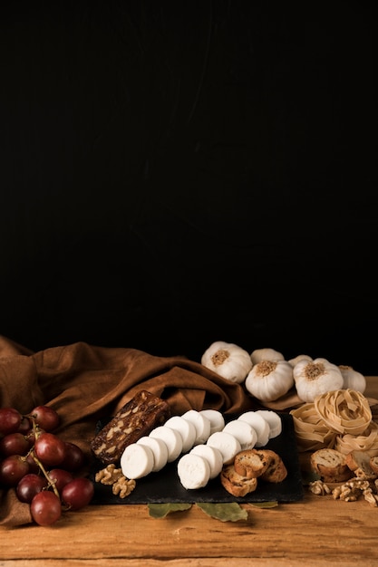 Savoureux aliments crus sur une table en bois contre du papier peint foncé