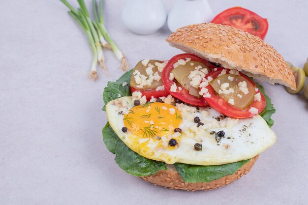 Savoureux burger avec tomate, fromage, laitue sur blanc.