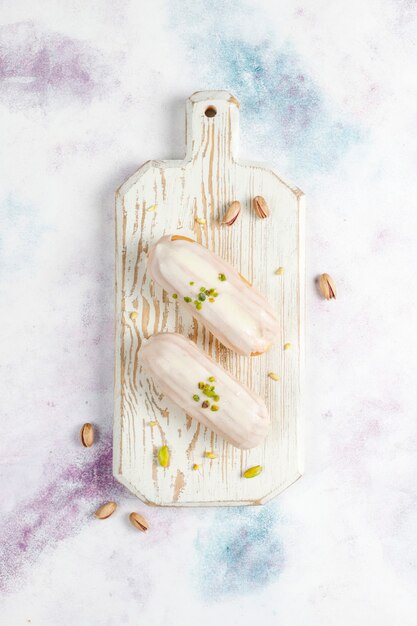 Photo gratuite savoureux éclairs à la pistache faits maison avec du chocolat blanc.