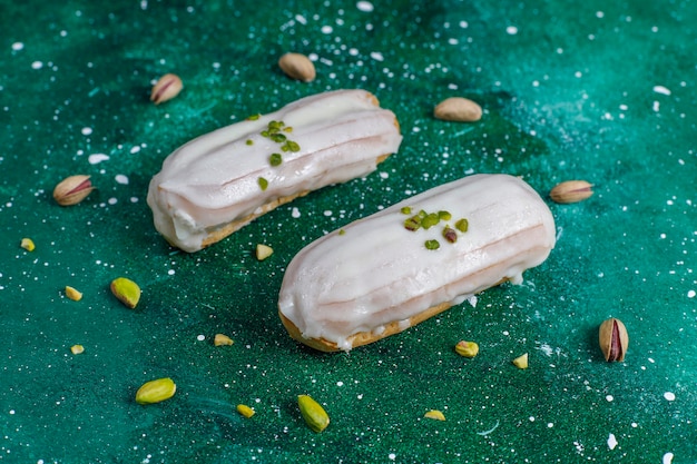 Photo gratuite savoureux éclairs à la pistache faits maison avec du chocolat blanc.