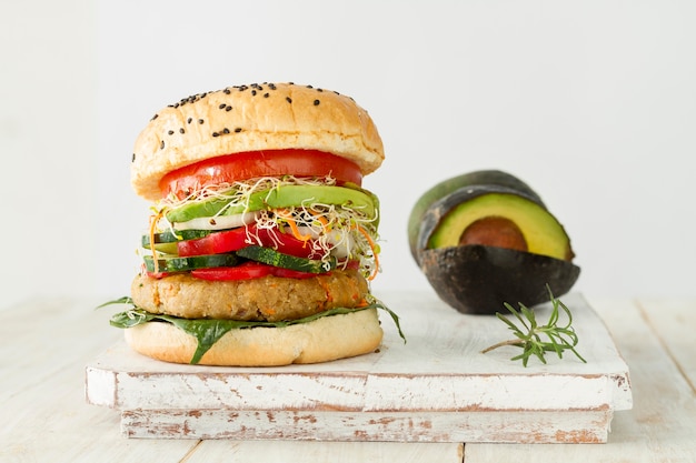 Savoureux hamburger et avocat sur planche de bois