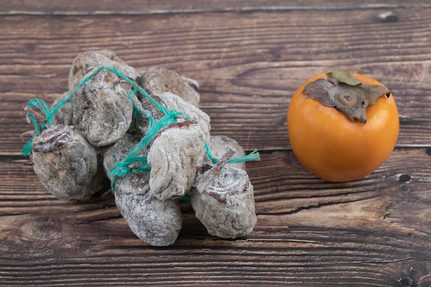 Savoureux kaki fuyu et kakis séchés sur une surface en bois