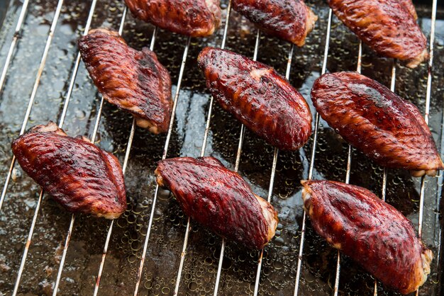 Savoureux morceaux de viande de poulet sur un gril métallique