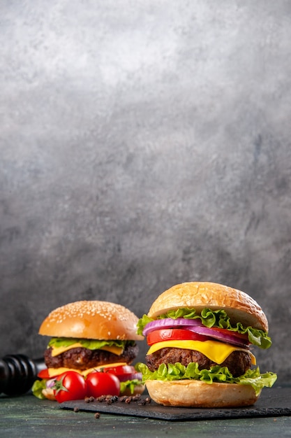 De savoureux sandwichs au poivre et aux tomates sur tableau noir sur une surface de couleur sombre