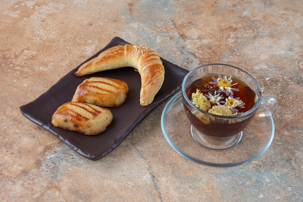 Savoureux thé à la camomille avec des biscuits sur marbre