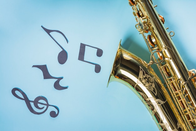 Saxophones doré avec des notes de musique sur fond bleu