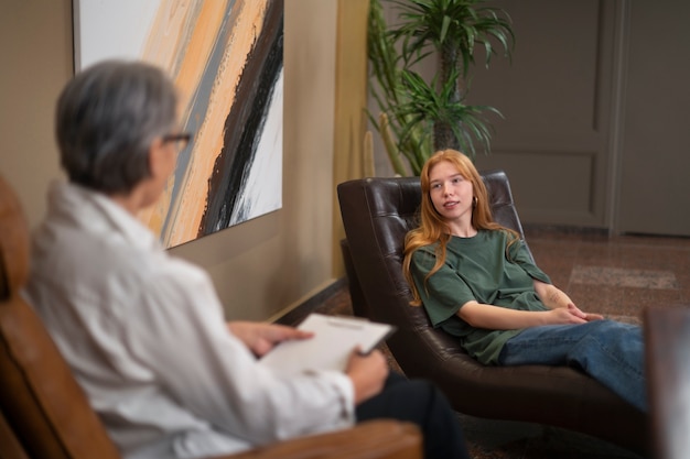 Photo gratuite scène authentique d'un jeune subissant une thérapie psychologique