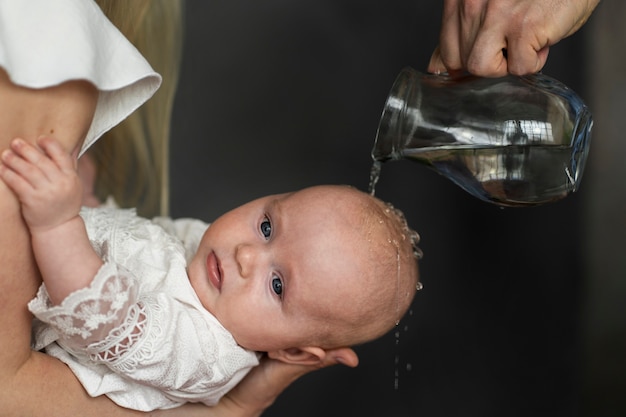 Photo gratuite scène de baptême de bébé vue de côté