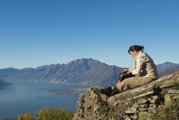 Scène à couper le souffle d'une femme assise au sommet de la montagne