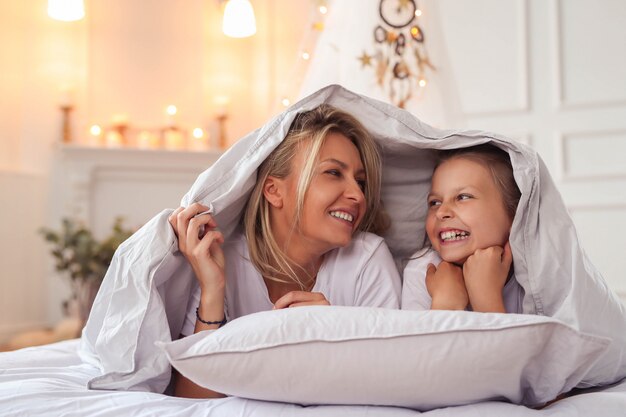 Scène de famille. Heureuse mère et fille dans un lit