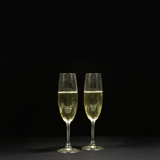 Scène noire avec deux coupes de champagne.