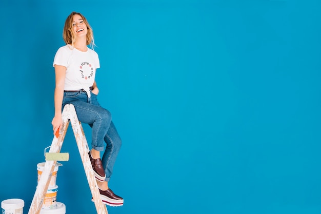 Photo gratuite scène de peinture avec une fille et un mur bleu