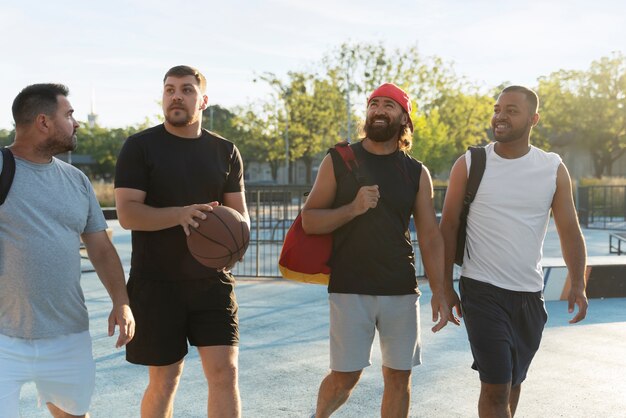 Photo gratuite des scènes authentiques d'hommes de taille plus grande jouant au basket-ball