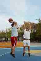 Photo gratuite des scènes authentiques d'hommes de taille plus grande jouant au basket-ball