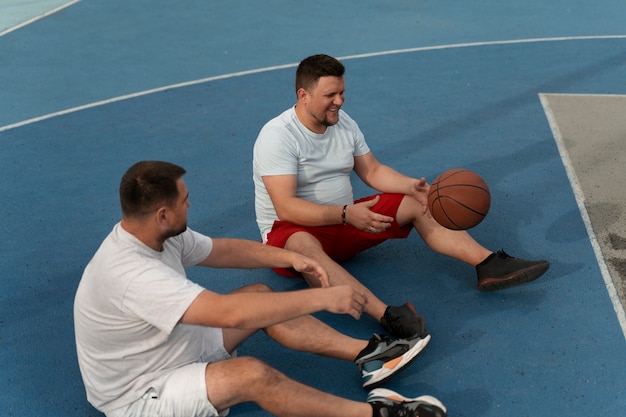 Des scènes authentiques d'hommes de taille plus grande jouant au basket-ball