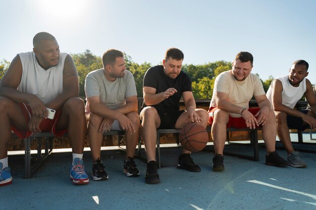 Des scènes authentiques d'hommes de taille plus grande jouant au basket-ball