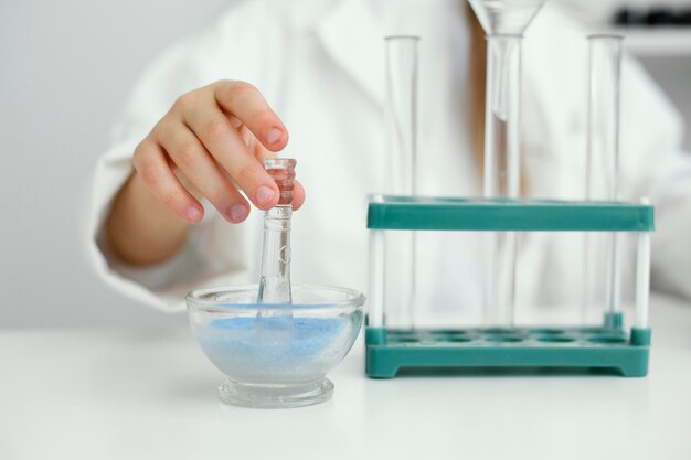 Scientifique de fille avec blouse de laboratoire et tubes à essai