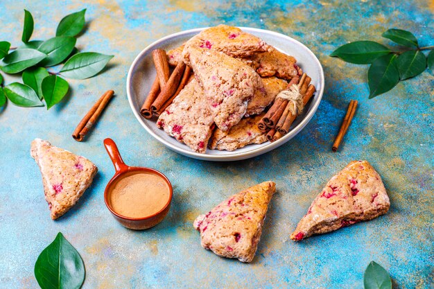 Scones anglais traditionnels faits maison avec framboises surgelées et cannelle, vue du dessus