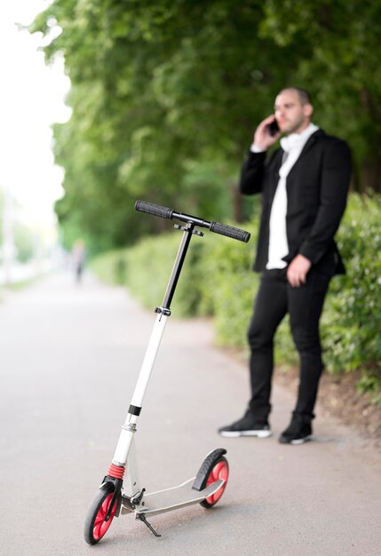 Photo gratuite scooter avec homme d'affaires, parler au téléphone