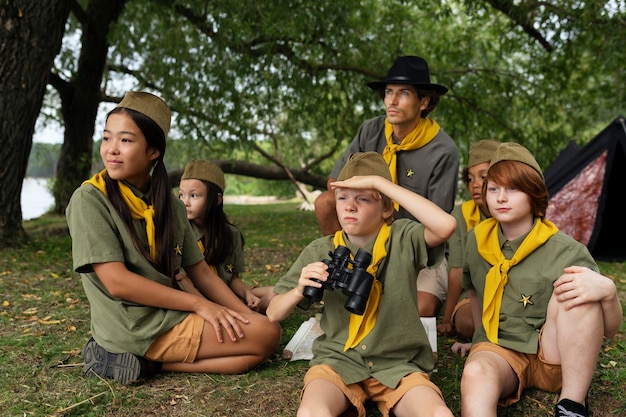 Photo gratuite scouts de vue de face avec des jumelles à l'extérieur